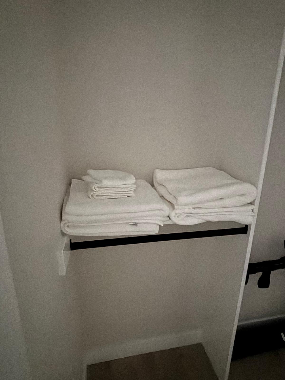 Neatly folded white towels on a clean shelf